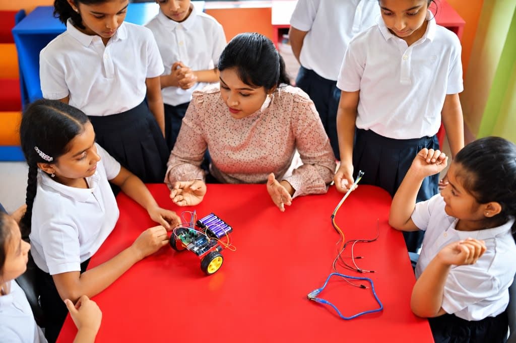 Students building a robot car in a MedhaArc classroom